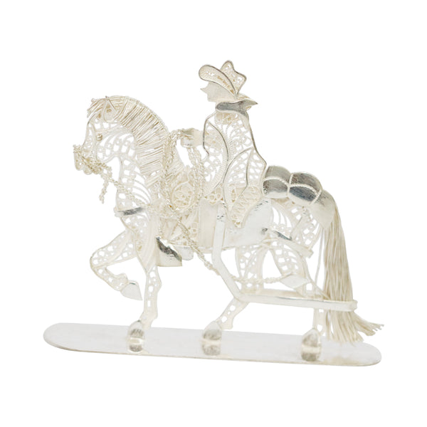 Chalán tradicional de filigrana de plata esterlina montando un caballo peruano de paso 